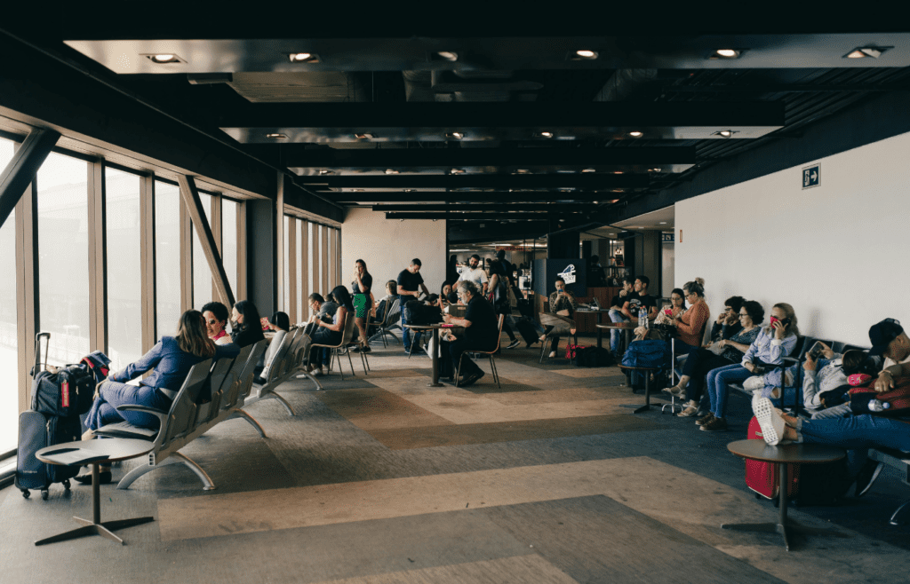 Travelers sitting inside terminal, waiting for boarding