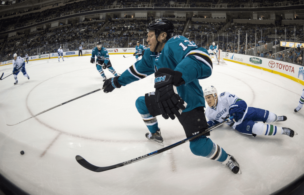 September 29, 2015; San Jose, CA, USA; San Jose Sharks left wing Raffi Torres (13) fights for the puck defended by Vancouver Canucks right wing Adam Cracknell (24) during the first period at SAP Center at San Jose. Mandatory Credit: Kyle Terada-Imagn Images