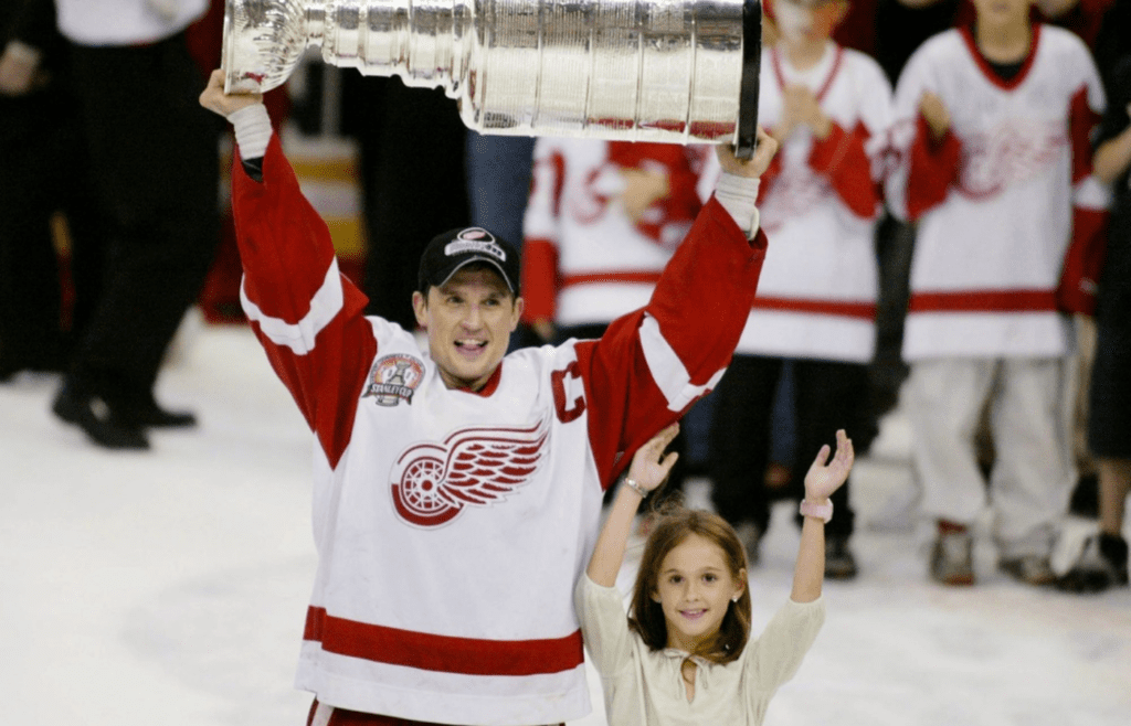 Steve Yzerman holds up the Stanley Cup with his daughter Isabella after winning the cup for the third time in 2002.