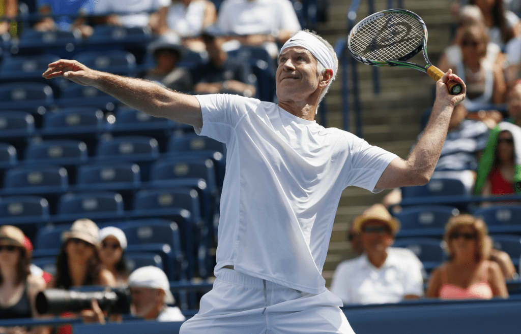 Aug 11, 2013; Toronto,ON, Canada; John McEnroe (USA) goes to serve to Jim Courier (USA) (not pictured) during the Legends exhibition game at the Rexall Centre. Mandatory Credit: John E. Sokolowski-Imagn Images