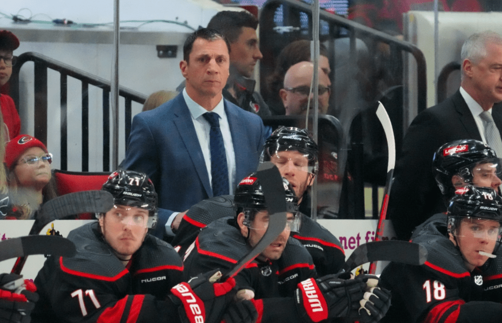 Apr 7, 2024; Raleigh, North Carolina, USA; Carolina Hurricanes head coach Rod Brind’Amour looks on from behind the players bench against the Columbus Blue Jackets during the second period at PNC Arena. Mandatory Credit: James Guillory-Imagn Images