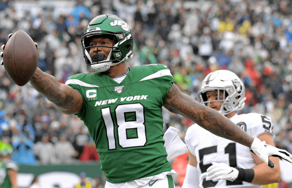 Nov 24, 2019; East Rutherford, NJ, USA; New York Jets wide receiver Demaryius Thomas (18) carries the ball past Oakland Raiders inside linebacker Will Compton (51) during the first half at MetLife Stadium. Mandatory Credit: Kirby Lee-Imagn Images