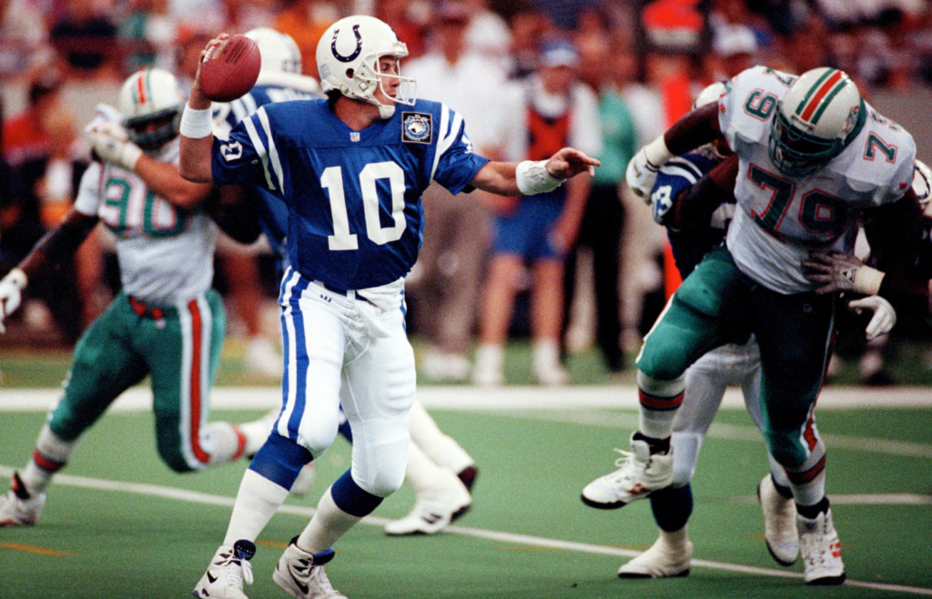 Jack Trudeau looked for a receiver under pressure from Dolphin Larry Webster, right, on the Colts home opener Sept. 5, 1993 at the Hoosier Dome. Trudeau was a Colt 1986-1993, starting 47 games. 01 Colts Dolphins 93