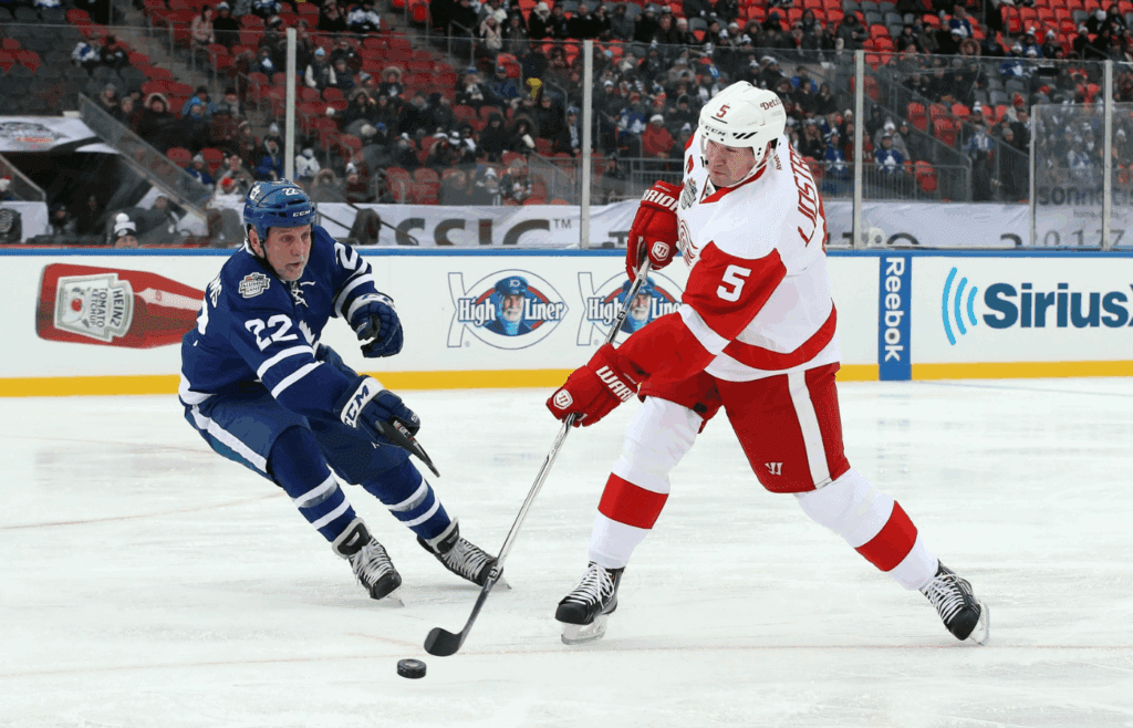 Dec 31, 2016; Toronto, ON, Canada; Toronto Maple Leafs forward Tiger Williams (22) defends as Detroit Red Wings defenseman Nicklas Lidstrom (5) shoots and scores a goal in the second period during the 2017 Rogers NHL Centennial Classic Alumni Game at BMO Field. The Red Wings beat the Maple Leafs 4-3. Mandatory Credit: Tom Szczerbowski-Imagn Images.
