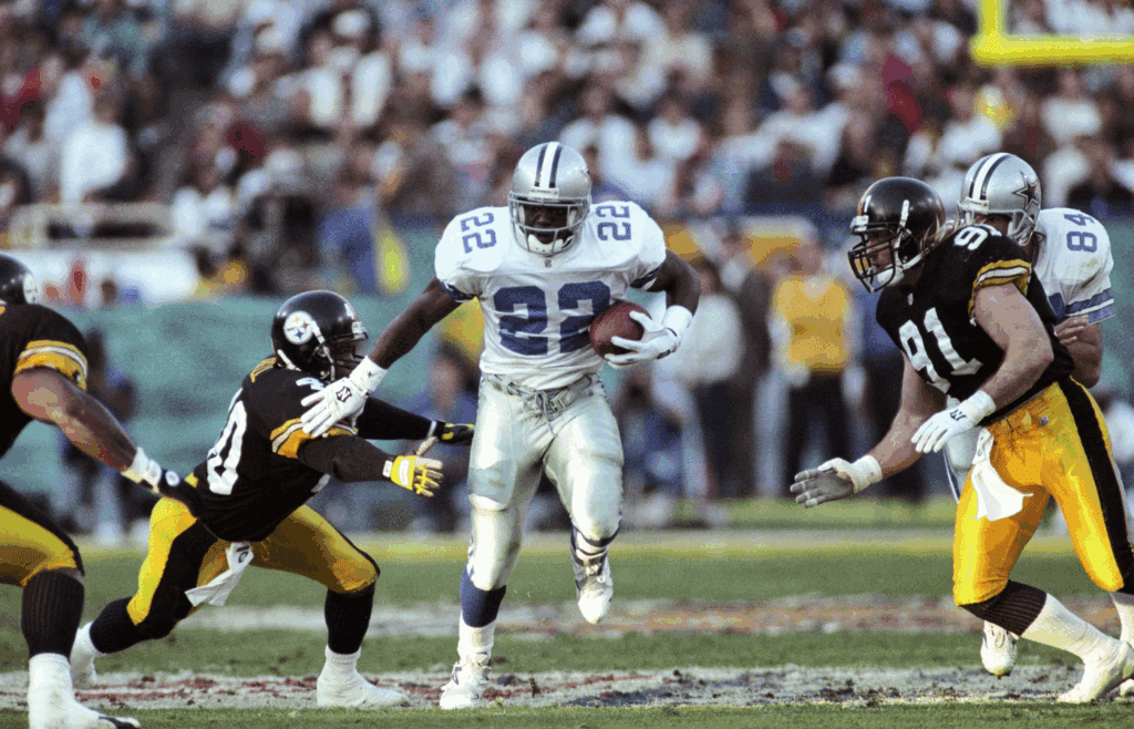 Jan 28, 1996; Tempe, AZ, USA; FILE PHOTO; Dallas Cowboys running back Emmitt Smith (22) carries the ball against Pittsburgh Steelers defenders Myron Bell (40) and Kevin Greene (91) during Super Bowl XXX at Sun Devil Stadium. Dallas defeated Pittsburgh 27-17. Mandatory Credit: Paul Gero/The Arizona Republic-Imagn Images
