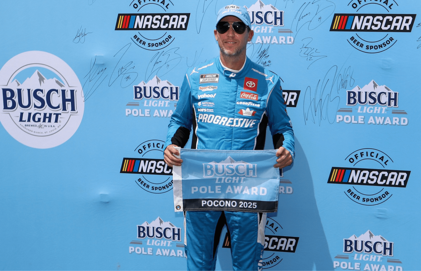 Jun 21, 2025; Long Pond, Pennsylvania, USA; NASCAR Cup Series driver Denny Hamlin stands with the Busch Light Pole Award after winning the pole for The Great American Getaway 400 at Pocono Raceway. Mandatory Credit: Matthew O'Haren-Imagn Images