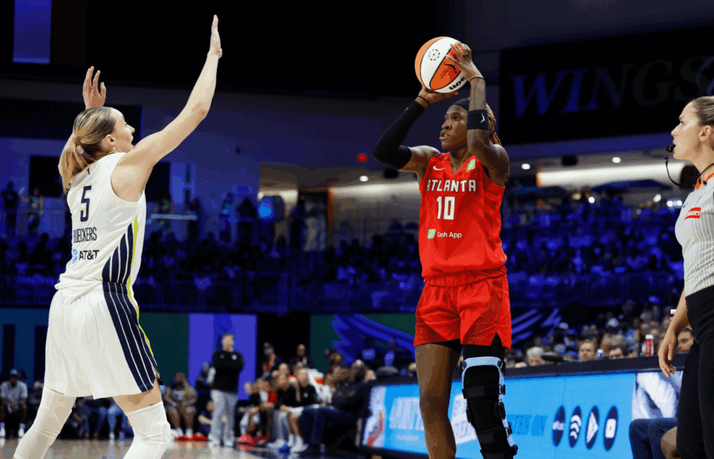Jun 24, 2025; Arlington, Texas, USA; Atlanta Dream guard Rhyne Howard (10) scores a three-point basket against Dallas Wings guard Paige Bueckers (5) during the first half at College Park Center. Mandatory Credit: Chris Jones-Imagn Images