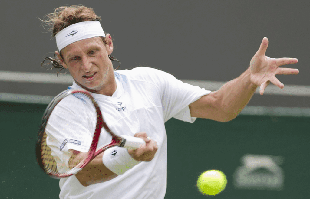 June 25, 2012; London, ENGLAND; David Nalbandian (ARG) returns a shot against Janko Tipsarevic (SRB) on day one of the 2012 Wimbledon Championships at the All England Lawn Tennis Club. Mandatory Credit: Susan Mullane-Imagn Images
