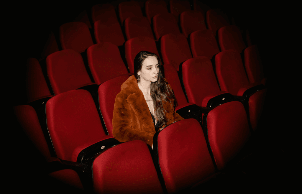 Female movie theater manager seated inside theater