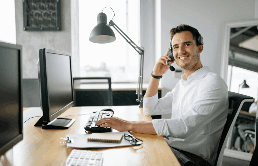 Male Personal Assistant in White Long Sleeve Shirt Sitting in Front of a Computer