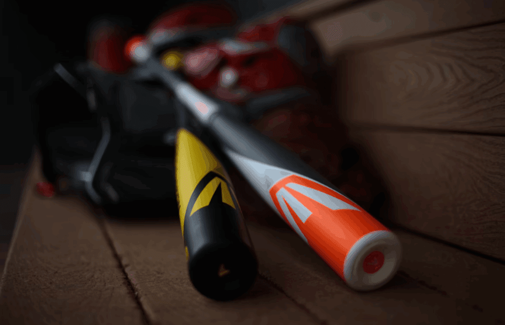 A baseball bat and a bag on a bench