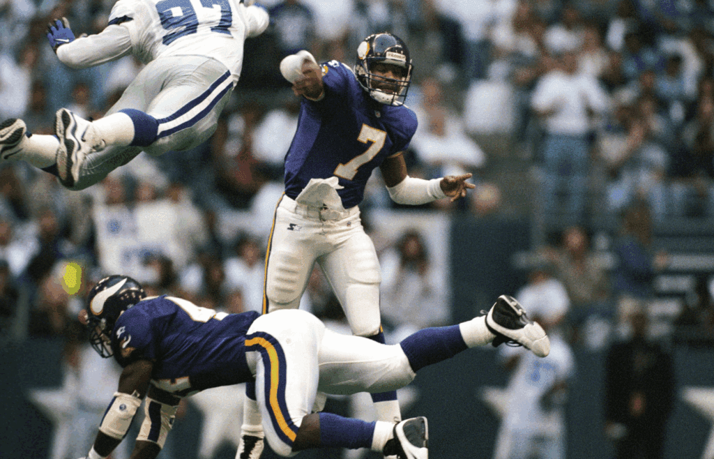 Nov 26, 1998; Irving, TX, USA; FILE PHOTO; Minnesota Vikings quarterback Randall Cunningham (7) is pressured as he releases the ball by Dallas Cowboys defensive end Kavita Pittman (97) during the 1998 season at Texas Stadium. Mandatory Credit: RVR Photos-Imagn Images