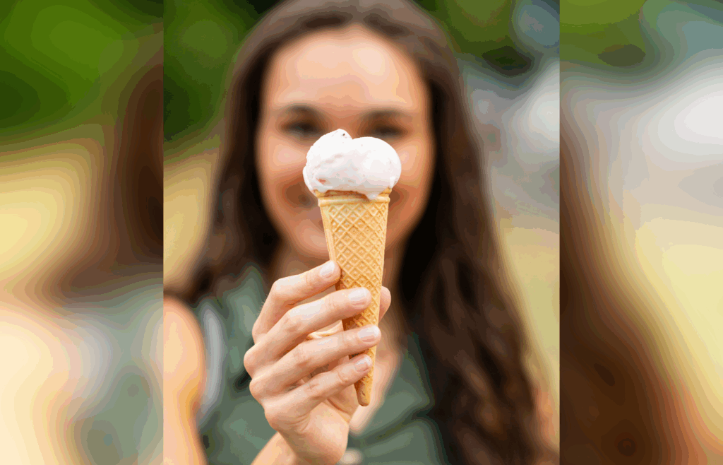Young Woman Holding Ice Cream Cone Outdoors in Summer
