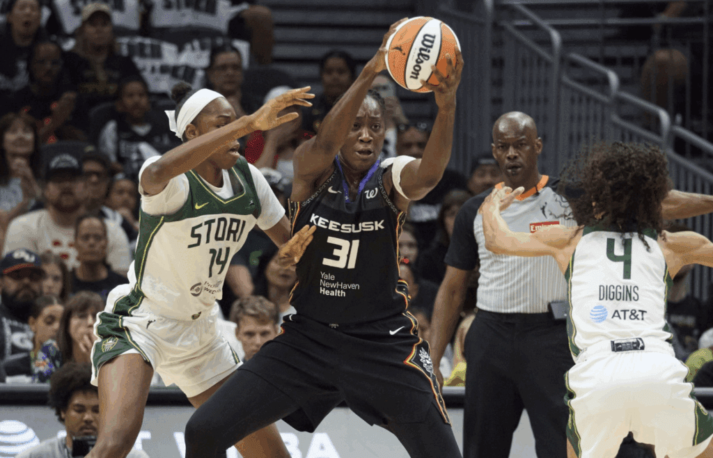 Jul 11, 2025; Seattle, Washington, USA; Connecticut Sun center Tina Charles (31) controls the ball against Seattle Storm center Dominique Malonga (14) and Seattle Storm guard Skylar Diggins (4) during the first half at Climate Pledge Arena. Mandatory Credit: John Froschauer-Imagn Images
