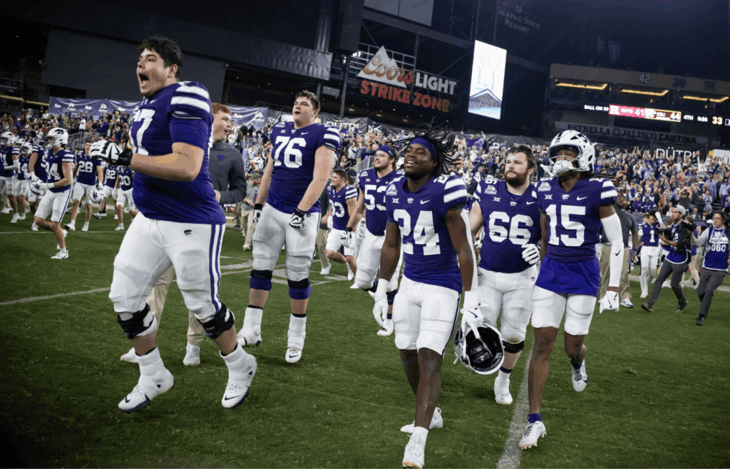 Dec 26, 2024; Phoenix, AZ, USA; Kansas State Wildcats offensive lineman Logan Cox (67) celebrates with running back JB Price (24) and wide receiver Trae Davis (15) after defeating the Rutgers Scarlet Knights during the Rate Bowl at Chase Field. Mandatory Credit: Mark J. Rebilas-Imagn Images