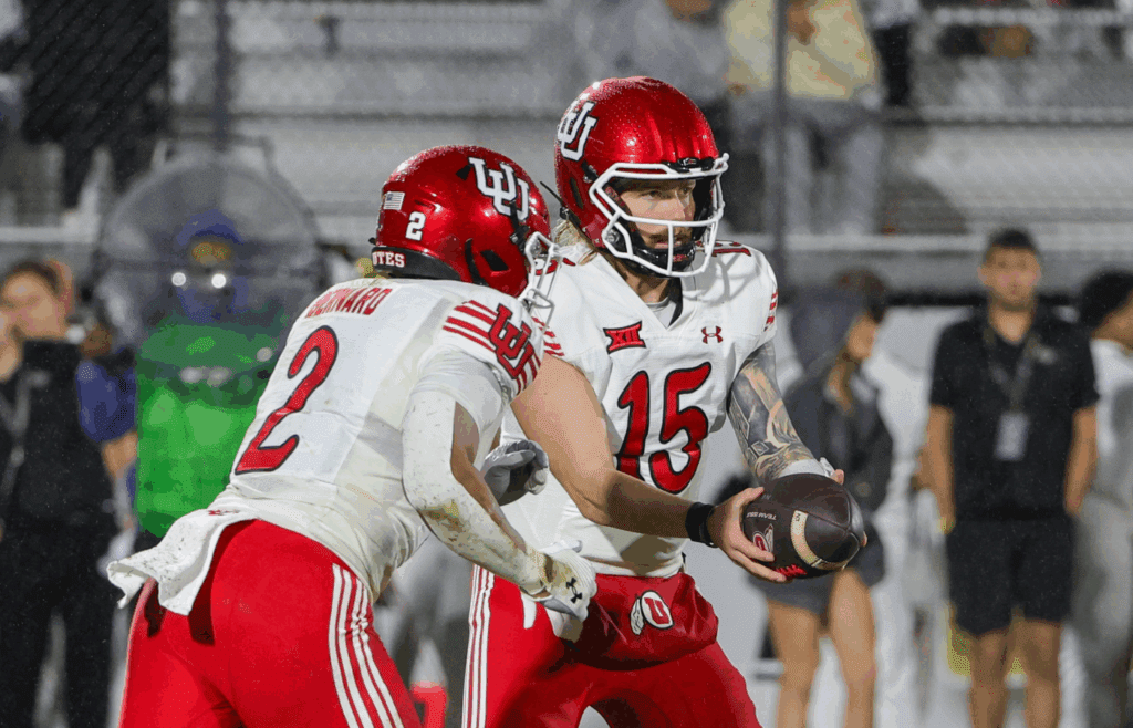Nov 29, 2024; Orlando, Florida, USA; Utah Utes quarterback Luke Bottari (15) hands off to running back Micah Bernard (2) during the second quarter at FBC Mortgage Stadium. Mandatory Credit: Mike Watters-Imagn Images