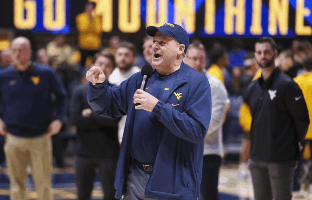 Feb 19, 2025; Morgantown, West Virginia, USA; West Virginia Mountaineers head football coach Rich Rodriguez speaks to the crowd during a timeout during the first half against the Cincinnati Bearcats at WVU Coliseum. Mandatory Credit: Ben Queen-Imagn Images
