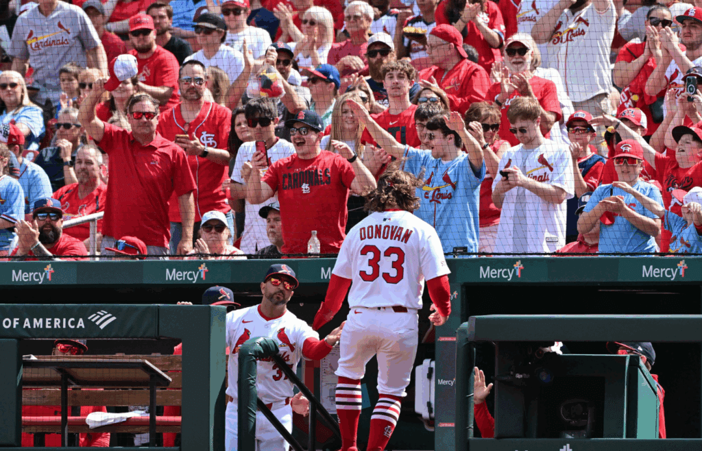 Apr 13, 2025; St. Louis, Missouri, USA; St. Louis Cardinals fans cheer as St. Louis Cardinals infielder Brendan Donovan (33) is congratulated by St. Louis Cardinals manager Oliver Marmol (37) after scoring against the Philadelphia Phillies at Busch Stadium. Mandatory Credit: Tim Vizer-Imagn Images