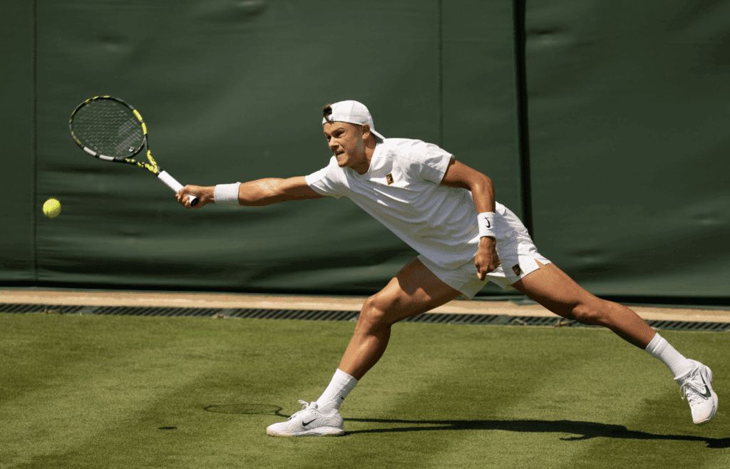 Jun 30, 2025; Wimbledon, UNITED KINGDOM; Holger Rune of Denmark returns a shot during his match against Nicolas Jarry of Chile on day one at the All England Lawn Tennis and Croquet Club. Mandatory Credit: Susan Mullane-Imagn Images