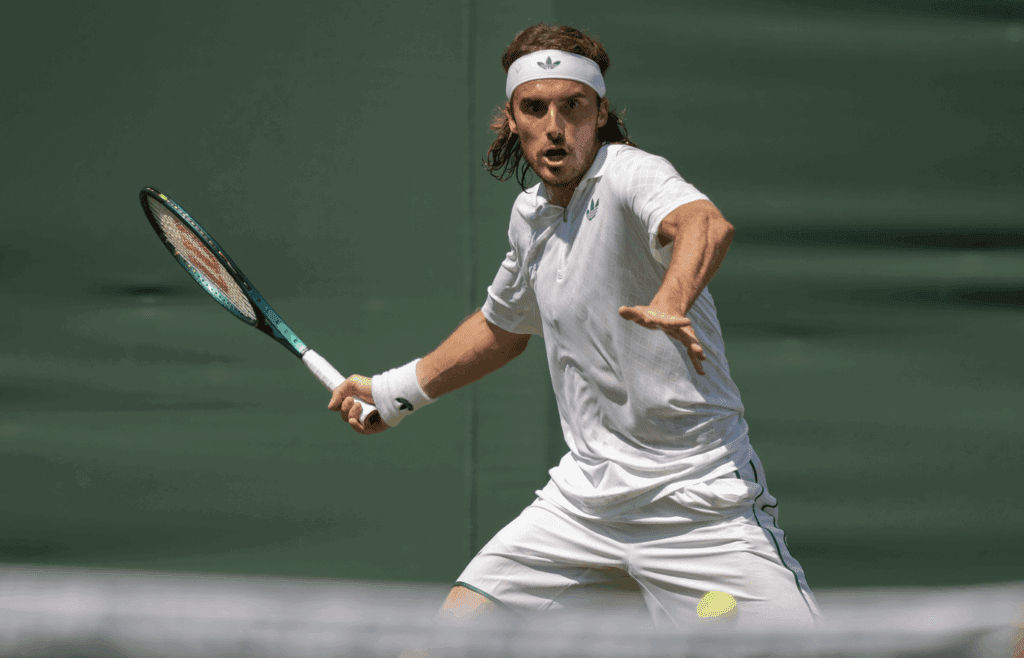 Jun 30, 2025; Wimbledon, UNITED KINGDOM; Stefanos Tsitsipas of Greece returns a shot during his match against Valentin Royer of France on day one at the All England Lawn Tennis and Croquet Club. Mandatory Credit: Susan Mullane-Imagn Images
