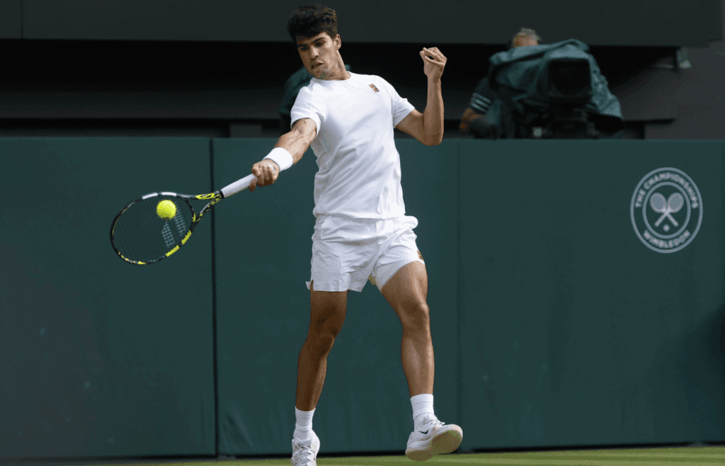 Jul 13, 2025; Wimbledon, United Kingdom; Carlos Alcaraz (ESP) hits a forehand against Jannik Sinner (ITA)(not pictured) in the gentlemen's' singles final of The Championships Wimbledon 2025 at All England Lawn Tennis and Croquet Club. Mandatory Credit: Geoff Burke-Imagn Images