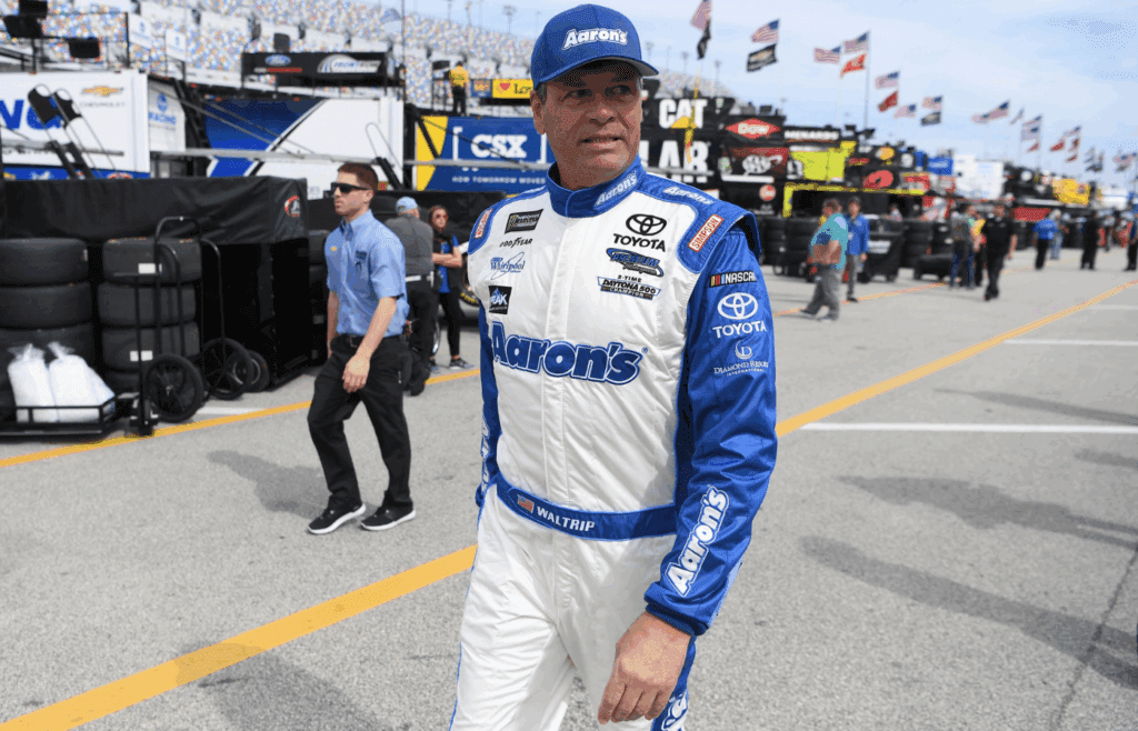 Feb 18, 2017; Daytona Beach, FL, USA; NASCAR Cup Series driver Michael Waltrip (15) walks through the garage area during practice for the Daytona 500 at Daytona International Speedway. Mandatory Credit: John David Mercer-Imagn Images