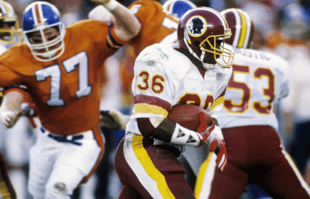 Jan 31, 1988; San Diego, CA, USA; FILE PHOTO; Washington Redskins running back Timmy Smith (36) carries the ball against Denver Broncos linebacker Karl Mecklenburg (77) during Super Bowl XXII at Jack Murphy Stadium. Washington defeated Denver 42-10. Mandatory Credit: Manny Rubio-Imagn Images