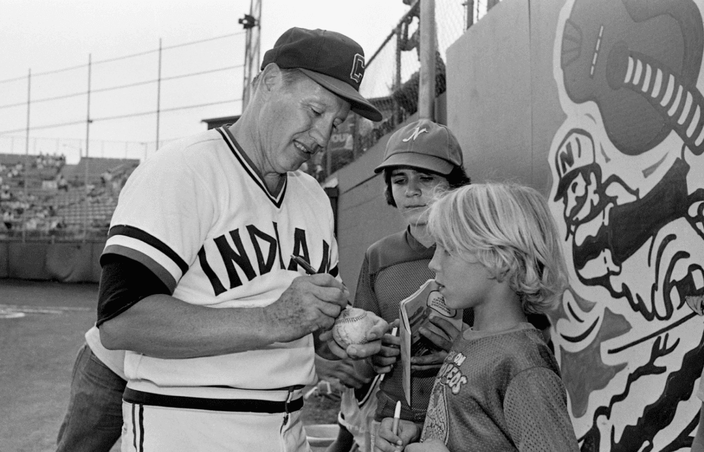 Former Cleveland Indians great Bob Feller autographs a ball for Steve Craig, right, as Gary Winfrey waits his turn with a program during the Hall of Famer pitcher special appearance for the Nashville Sounds game at Greer Stadium Aug. 2, 1979. 79then08 001