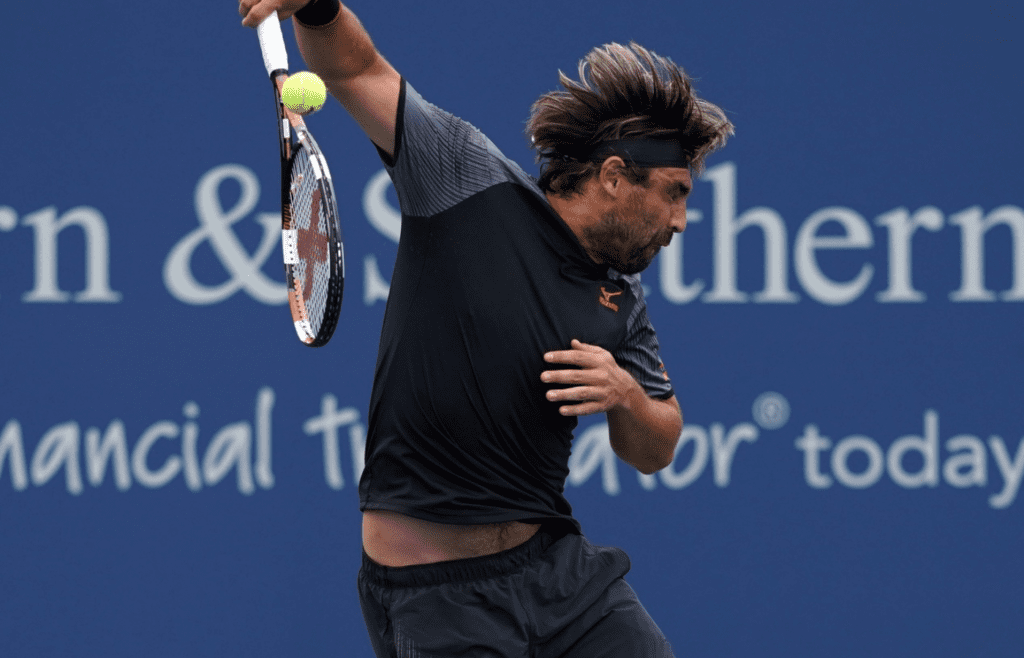 Aug 11, 2018; Mason, OH, USA; Marcos Baghdatis (CYP) returns a shot against Feliciano Lopez (ESP) in the Western and Southern tennis open at Lindner Family Tennis Center. Mandatory Credit: Aaron Doster-Imagn Images