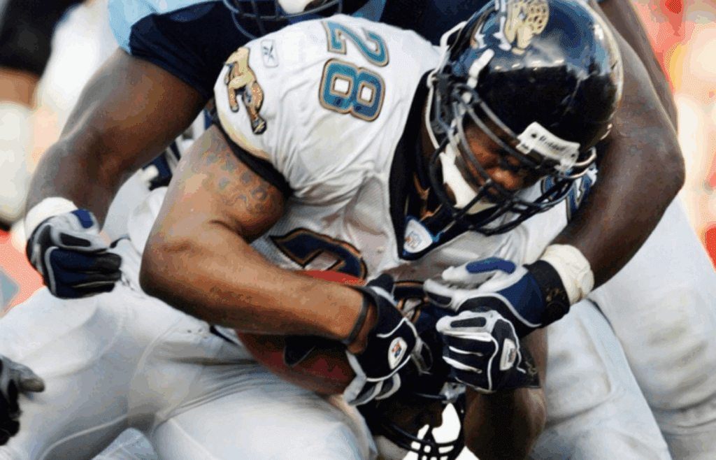 Tennessee Titans rookie defensive lineman Albert Haynesworth (91) stops Jacksonville Jaguars running back Fred Taylor (28) during action at the Nashville Coliseum on Oct. 13, 2002.