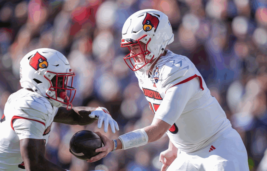 Louisville quarterback Harrison Bailey (15) hands off to Isaac Brown (25) against Washington at the Tony the Tiger Sun Bowl on Dec. 31, 2024.