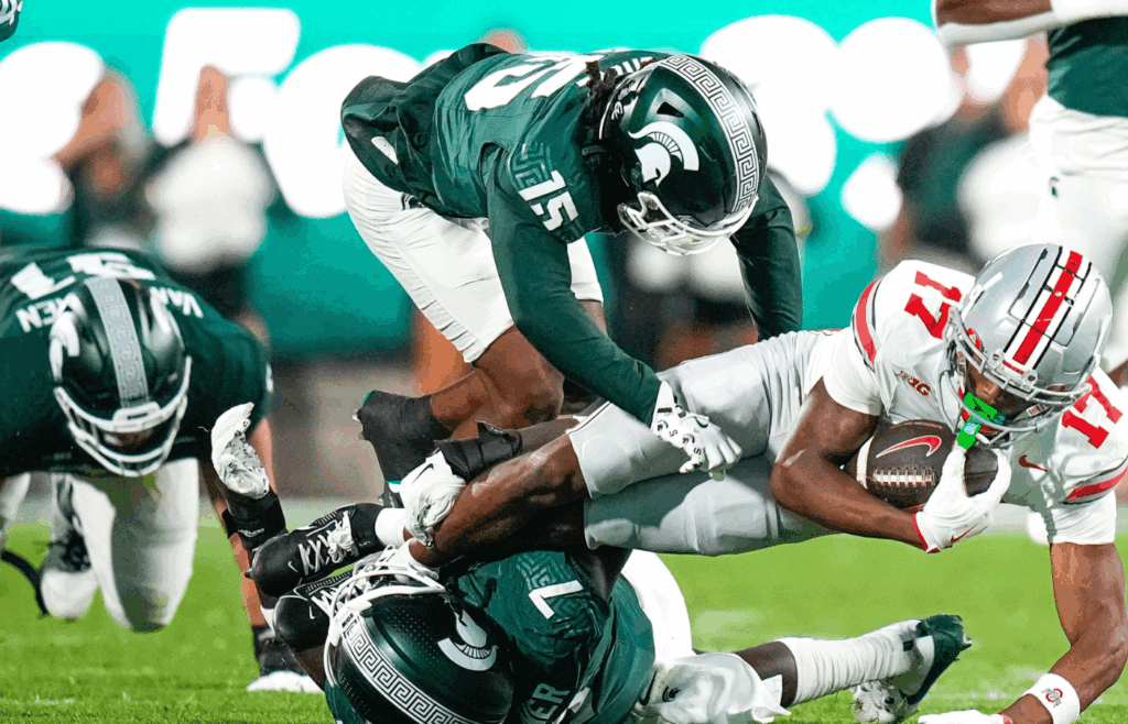 Sep 28, 2024; East Lansing, Michigan, USA; Ohio State Buckeyes wide receiver Carnell Tate (17) is tackled by Michigan State Spartans in the first half at Spartan Stadium on Saturday.