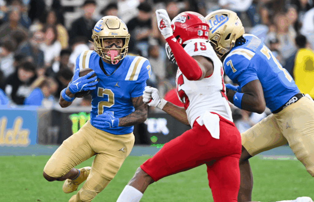 Nov 30, 2024; Pasadena, California, USA; UCLA Bruins wide receiver Titus Mokiao-Atimalala (2) tries to run past Fresno State Bulldogs defensive back Julian Neal (15) during the fourth quarter at Rose Bowl. Mandatory Credit: Robert Hanashiro-Imagn Images