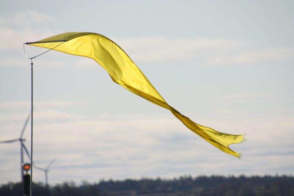 A yellow flag flutters in the wind