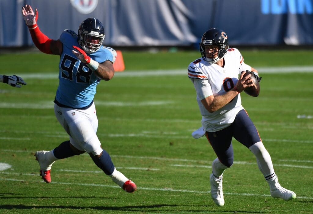 Nov 8, 2020; Nashville, Tennessee, USA; Chicago Bears quarterback Nick Foles (9) runs away from pressure by Tennessee Titans defensive tackle Jeffery Simmons (98) during the first half at Nissan Stadium. Mandatory Credit: Christopher Hanewinckel-USA TODAY Sports