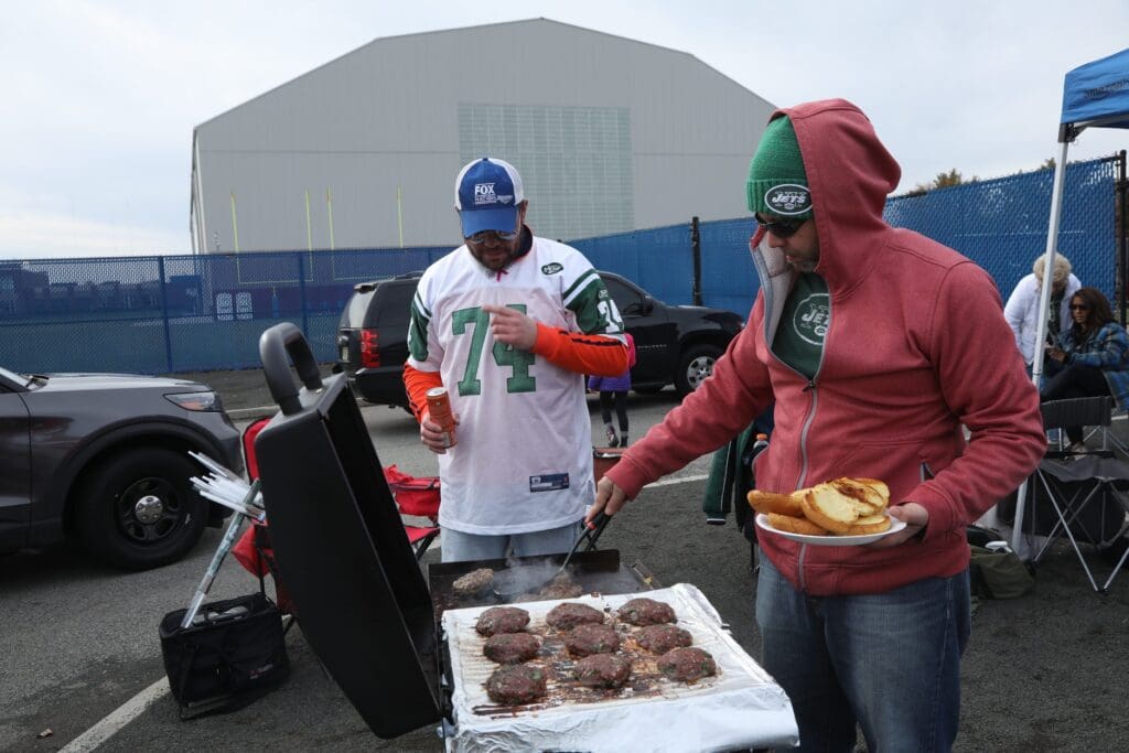 Lamb burgers cook on the grill at a tailgate to celebrate NY Jets head coach Robert Saleh in the parking lot at MetLife Stadium before the Buffalo Bills played the New York Jets in East Rutherford, NJ on Nov. 14, 2021.
ny jets tailgate