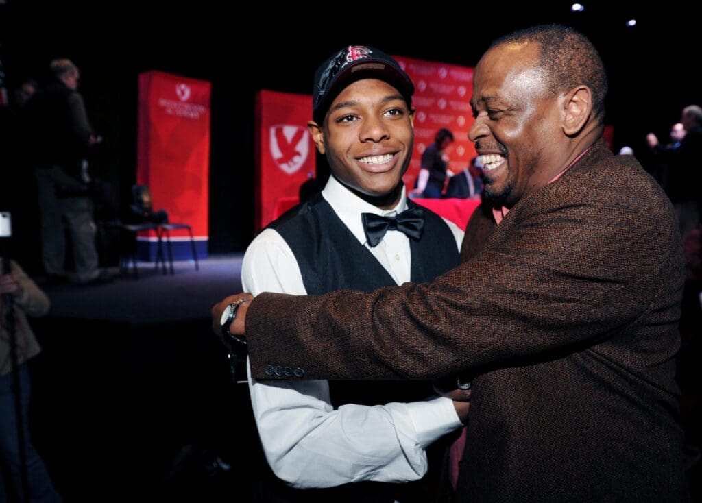 Brentwood Academy defensive back Jalen Ramsey, left, gets a hug from family friend Reynolds Gaulden after Ramsey commits to Florida State on Feb. 6, 2013, during a press conference at the school.