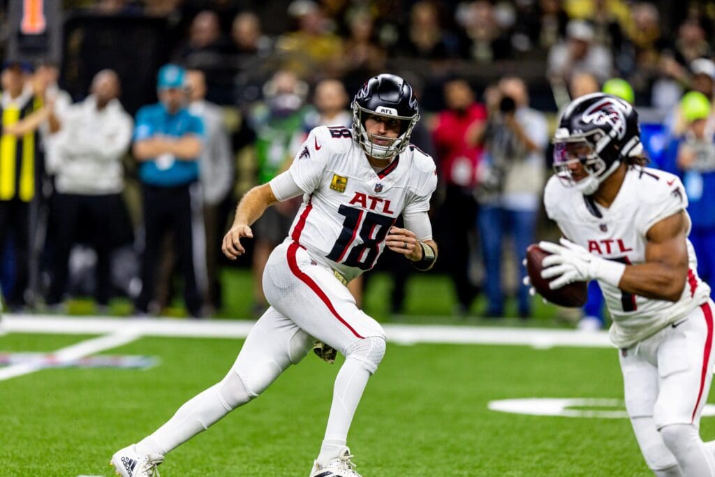 Nov 10, 2024; New Orleans, Louisiana, USA;   Atlanta Falcons quarterback Kirk Cousins (18) tosses the ball to running back Bijan Robinson (7) against the New Orleans Saints during the first half at Caesars Superdome. Mandatory Credit: Stephen Lew-Imagn Images
