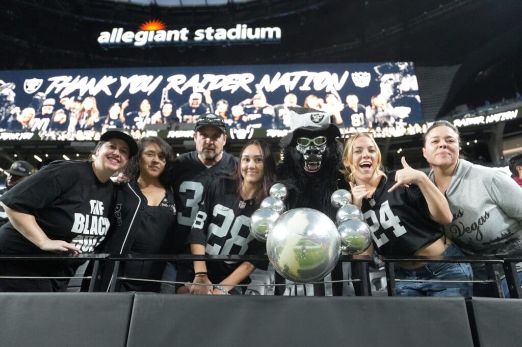 Jan 5, 2025; Paradise, Nevada, USA; Las Vegas Raiders fans (from left) Marilyn Acasio aka Jungle Jane, Maria Lopez, Geoff Skarr, Alyssa Skarr, Mark Acasio aka Gorilla Rilla, Amber Mielke and Monica Martinez pose during the game against the Los Angeles Chargers at Allegiant Stadium. Mandatory Credit: Kirby Lee-Imagn Images