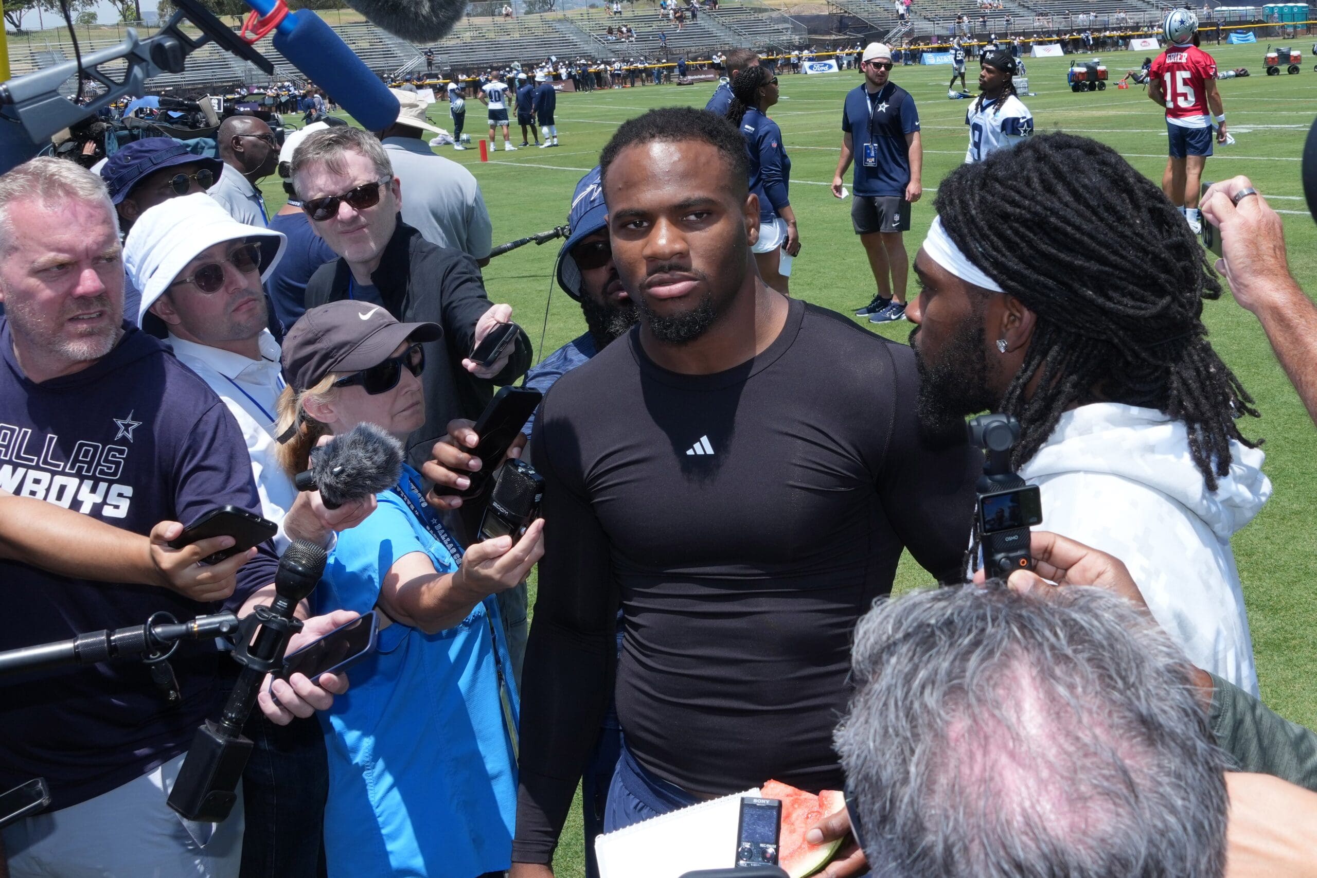 Jul 22, 2025; Oxnard, CA, USA; Dallas Cowboys defensive end Micah Parsons (left) and cornerback Trevon Diggs talks to media during training camp at the River Ridge Fields. Mandatory Credit: Kirby Lee-Imagn Images