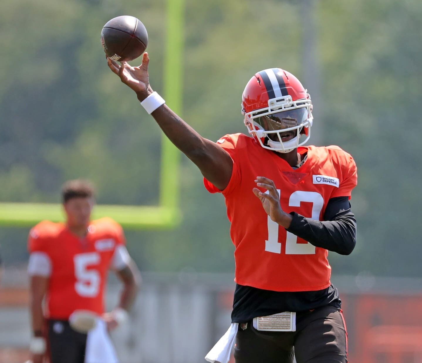 Cleveland Browns quarterback Shedeur Sanders (12) throws as quarterback Dillon Gabriel (5) looks on during NFL training camp at CrossCountry Mortgage Campus, Friday, Aug. 1, 2025, in Berea, Ohio.