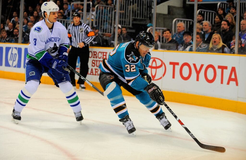 Jan. 20, 2009; San Jose, CA, USA; San Jose Sharks right wing Claude Lemieux (32) controls the puck in front of Vancouver Canucks defenseman Kevin Bieksa (3) during the second period at HP Pavilion. Mandatory Credit: Kyle Terada-USA TODAY Sports