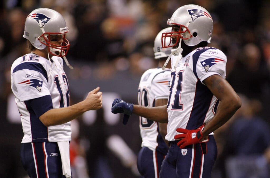 Nov. 30, 2009; New Orleans, LA, USA; New England Patriots quarterback Tom Brady (12) bump fists with wide receiver Randy Moss (81) during pregame warmups against the New Orleans Saints at the Louisiana Superdome. Mandatory Credit: John David Mercer-USA TODAY Sports