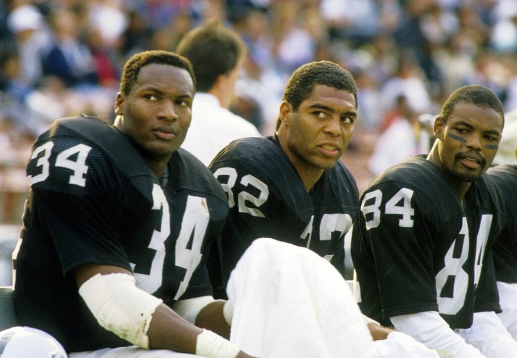 Dec 6, 1987; Los Angeles, CA, USA; FILE PHOTO; Los Angeles Raiders running back Marcus Allen (32), Bo Jackson (34) and Jesse Hester (84) on the bench against the Buffalo Bills at the Coliseum. Mandatory Credit: MPS-USA TODAY Sports