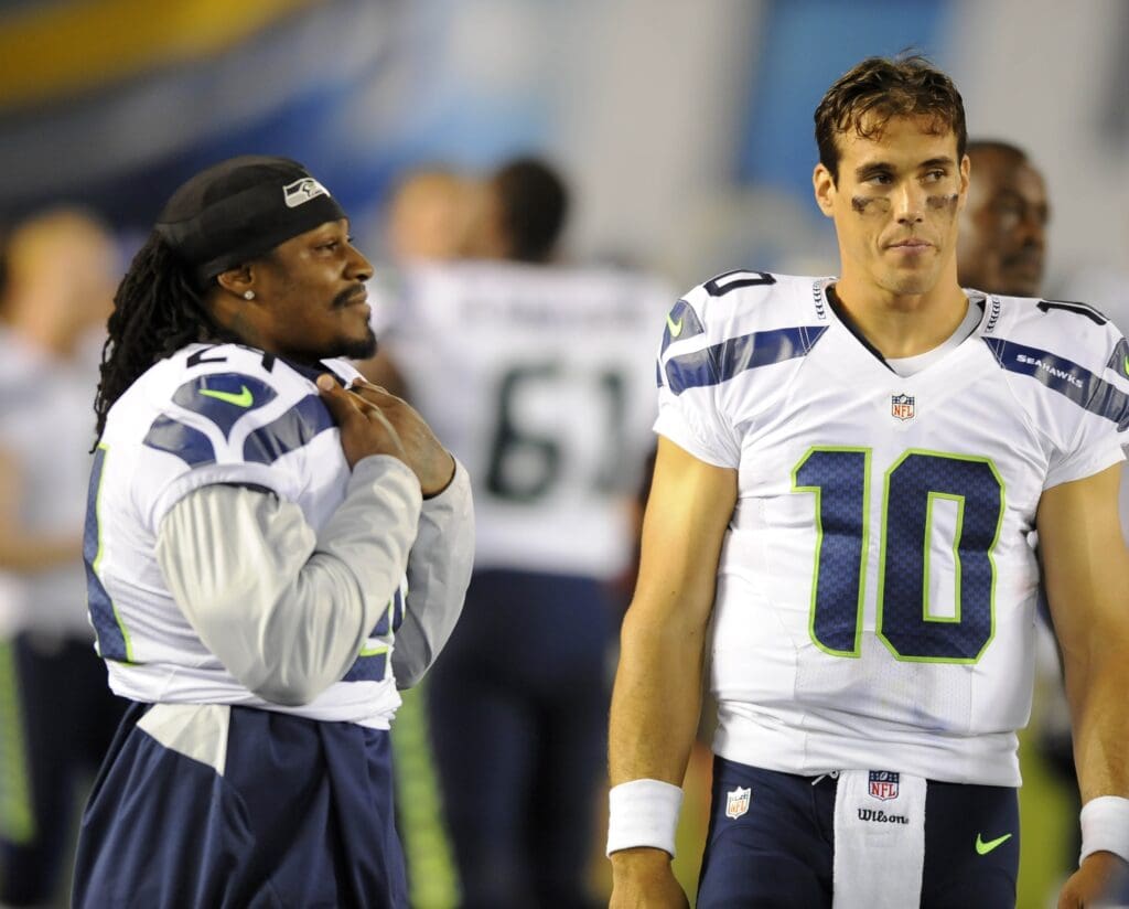 Aug 8, 2013; San Diego, CA, USA; Seattle Seahawks quarterback Brady Quinn (10) talks with Seattle running back Marshawn Lynch (24) on the sidelines during the second half against the San Diego Chargers at Qualcomm Stadium. Mandatory Credit: Christopher Hanewinckel-USA TODAY Sports