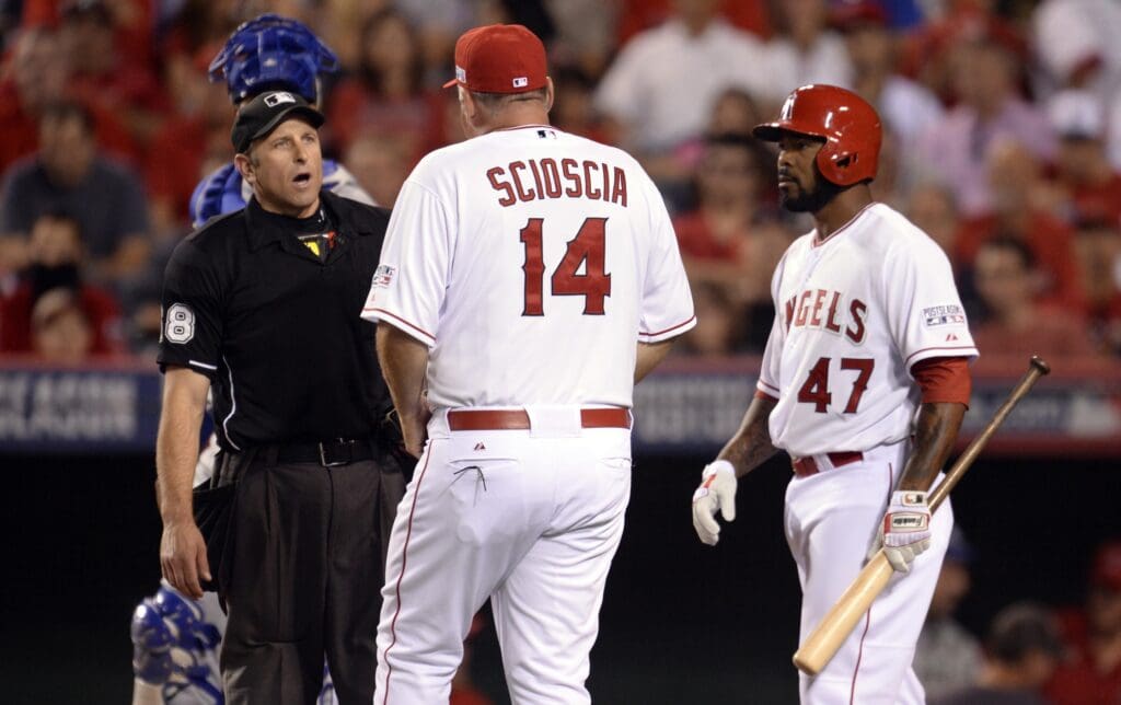 Oct 3, 2014; Anaheim, CA, USA; Los Angeles Angels manager Mike Scioscia (14) comes out to speak with umpire Chris Guccione (68) on a strike call to second baseman Howie Kendrick (47) in game two of the 2014 ALDS playoff baseball game against the Kansas City Royals at Angel Stadium of Anaheim. Mandatory Credit: Robert Hanashiro-USA TODAY Sports