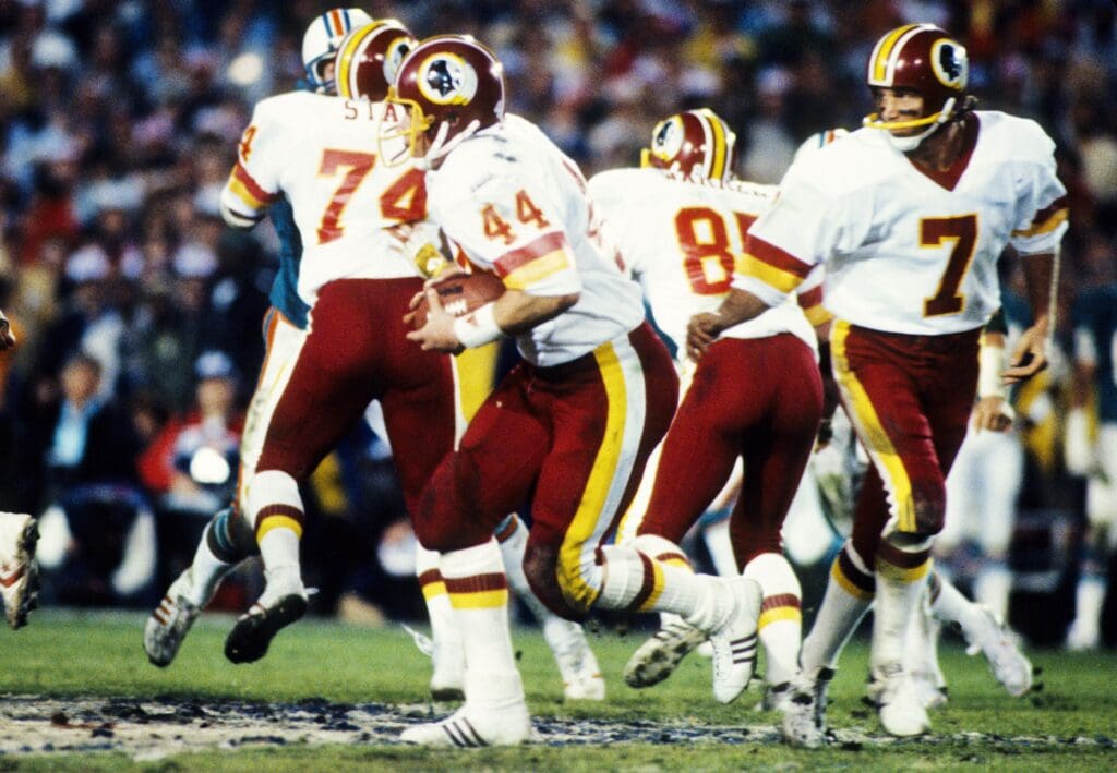 Jan 30, 1983; Pasadena, CA, USA; FILE PHOTO; Washington Redskins quarterback Joe Theismann (7) hands the ball off to John Riggins (44) against the Miami Dolphins during Super Bowl XVII at the Rose Bowl. The Redskins defeated the Dolphins 27-17. Mandatory Credit: Manny Rubio-USA TODAY Sports