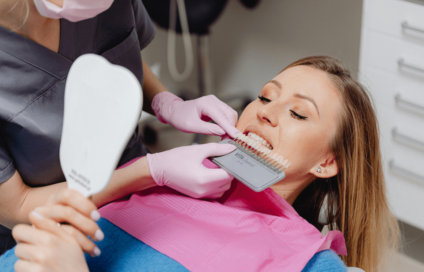Dentist comparing teeth shades for whitening