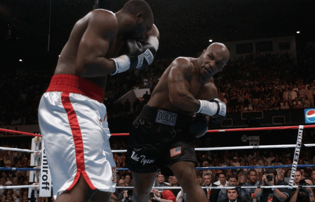 Mike Tyson delivers a shot to Danny Williams, but the 9-1 underdog scored a stunning upset at Freedom Hall in Louisville, July 30, 2004.