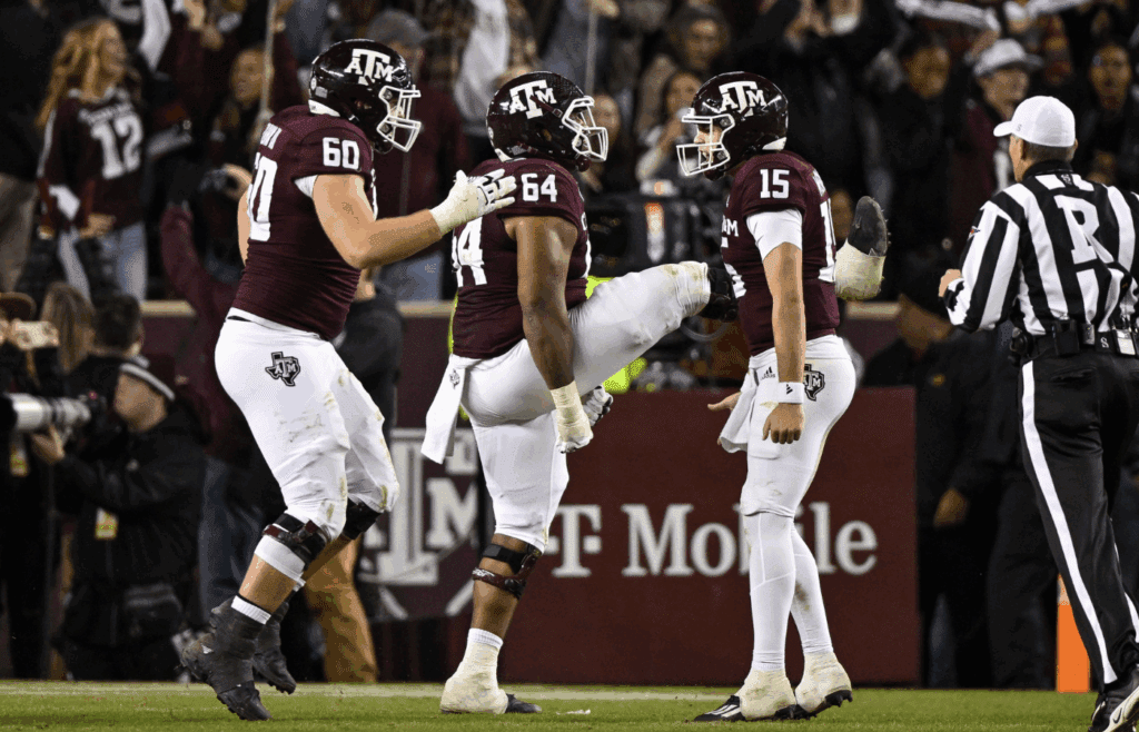 Nov 26, 2022; College Station, Texas, USA; Texas A&M Aggies quarterback Conner Weigman (15) and offensive lineman Layden Robinson (64) and offensive lineman Trey Zuhn III (60) celebrates a touchdown against the LSU Tigers during the second half at Kyle Field. Mandatory Credit: Jerome Miron-Imagn Images